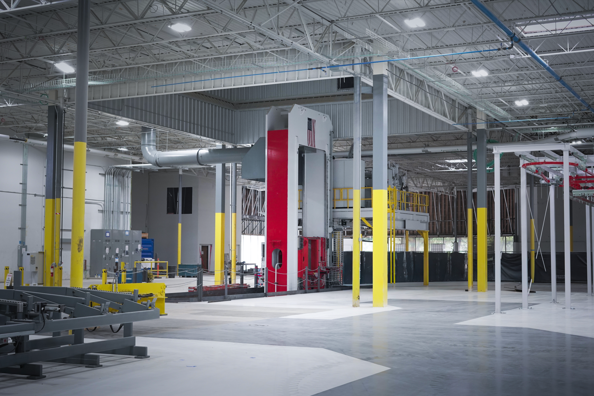 Forge press on the factory floor with a heated billet in position.