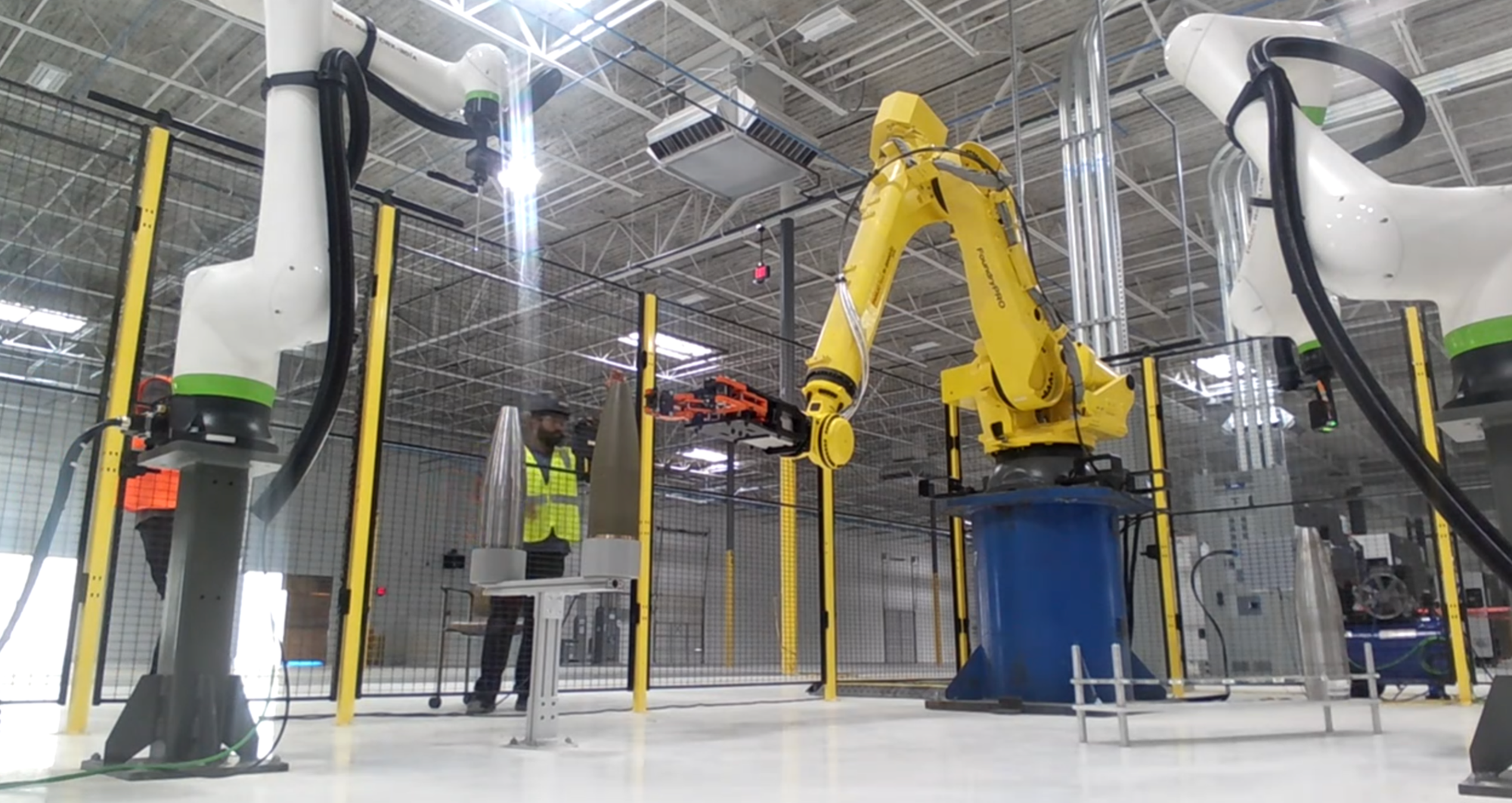 Robotic cell moving a part between stations on the production line.